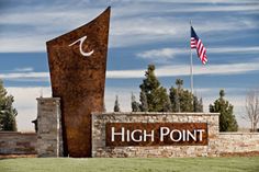 the entrance sign to high point is shown in front of an american flag and two flags