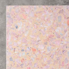 a tile floor with pink and blue colors on it, in an area that looks like concrete