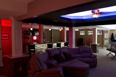 a living room filled with purple couches next to a dining room table and chairs