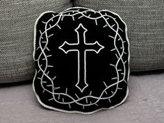 a black and white pillow with a cross on it