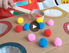 a child is making pom poms out of cardboard