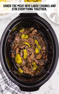 a crock pot filled with shredded beef and pickled up jalapenos