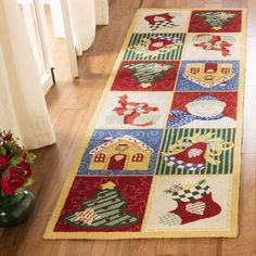 a red and green rug with christmas decorations on the floor next to a vase filled with flowers