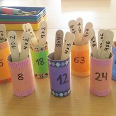 several pencils in cups with numbers on them