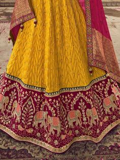 Let the festive charm and warmth reflect in your dressing with this scintillating outfit. This beautiful yellow color lehenga is made of viscose material adorned with sequin work, thread, and embroidery work with gorgeous elephant motifs. This sweet yellow lehenga comes with a red color blouse of viscose silk material designed with sequin, thread, and embroidery work. It also comes with a red color organza material dupatta crafted with zari weaving and bandhani print with precious lace border wo Haldi Function, Yellow Lehenga, Work Lehenga, Color Blouse, Organza Dupatta, Lace Border, Silk Material, Embroidery Work, Material Design