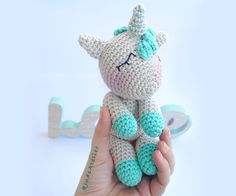 a small crocheted stuffed animal with a unicorn on it's head sitting in someones hand