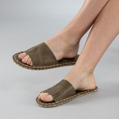 Introducing the Green Barefoot Slide Sandals - the perfect addition to your summer wardrobe. Handmade in Turkey with 100% natural materials, these sandals are crafted with a natural leather upper and a water buffalo leather sole, ensuring maximum comfort and breathability for your feet. With a wider toe box, your toes have enough room to spread and relax, promoting a more natural gait and posture. The "zero-drop" non-elevated heel helps maintain proper posture as well. Available in sizes ranging Beach Slip-on Slingback Sandals With Leather Sole, Leather Slip-on Slingback Sandals For Beach, Summer Closed Toe Slippers With Leather Footbed, Closed Toe Slippers With Leather Footbed For Summer, Summer Leather Slippers With Stitched Sole, Leather Slippers With Stitched Sole For Summer, Open Toe Beach Slides With Stitched Sole, Vacation Slingback Sandals With Rubber Sole, Vacation Slingback Sandals With Open Heel And Rubber Sole