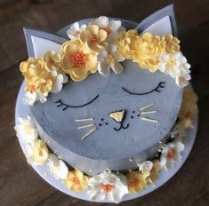 a cake decorated with flowers and a cat's face