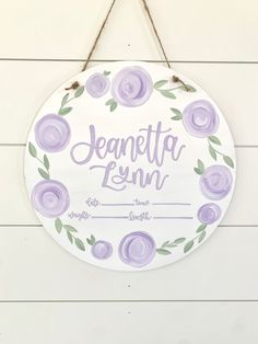 a sign hanging on the side of a wall that says jeanette lynn with purple flowers