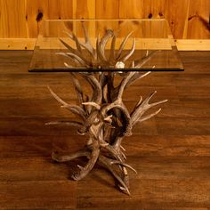 a glass table topped with antlers on top of a wooden floor