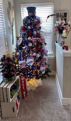 a decorated christmas tree with red, white and blue decorations in the shape of an american flag