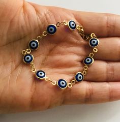 "18k gold filled dark blue evil eye bracelet for good luck, prosperity and protection. 5,25\" long for baby. pulsera de ojo azul oscuro de la buena suerte en 18k gold filled para prosperidad,buena suerte y poteccion. bebe 5,25\" largo." Blue Evil Eye Bracelet For Good Luck, Cheap Gold Hand-strung Evil Eye Bracelet, Blue Evil Eye Metal Bracelet, Blue Metal Evil Eye Bracelet, Adjustable Blue Evil Eye Bracelet Hand-strung, Good Luck Bracelet, Baby #5, Protection Bracelet, Blue Evil Eye