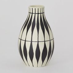 a black and white striped vase sitting on top of a table