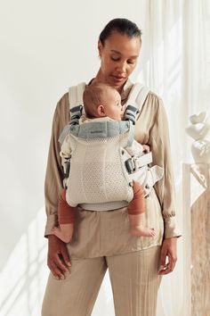 a woman holding a baby in a sling