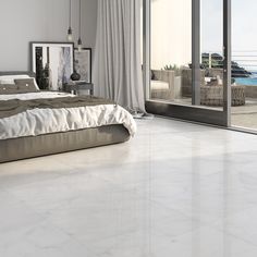 a bedroom with white marble flooring and large sliding glass doors leading to the balcony