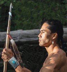 a native american man holding a bow and arrow