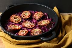 an iron skillet filled with food on top of a wooden table