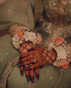 a close up of a person's hands holding flowers