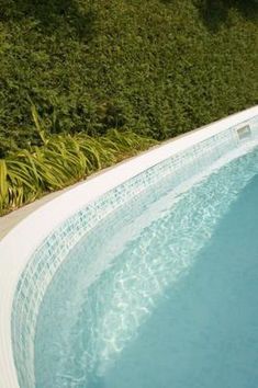 an above ground swimming pool surrounded by grass