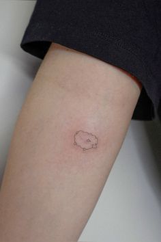 a small tattoo on the arm of a woman's left leg, with a white cloud in the middle