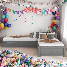 a birthday party with balloons and confetti on the ceiling, bed in foreground