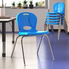 several blue chairs sitting in a room next to a black table and white tile floor