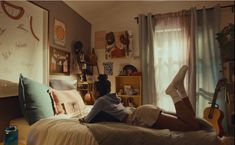 a woman laying on top of a bed next to a book shelf filled with books