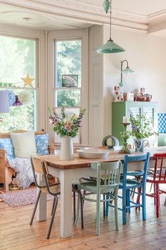 a dining room table with four chairs in front of it and a window behind it