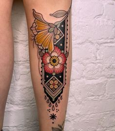 a woman's leg with tattoos and flowers on it