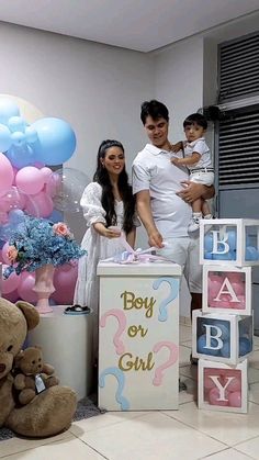 a man, woman and child are standing in front of boxes with baby's names on them