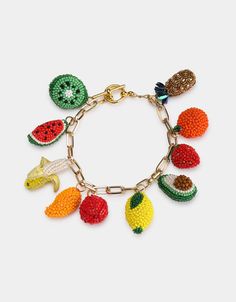 a bracelet with fruits and vegetables on the link, hanging from a gold plated chain