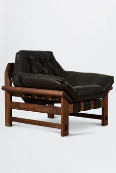 a black leather chaise lounge chair sitting on top of a wooden frame