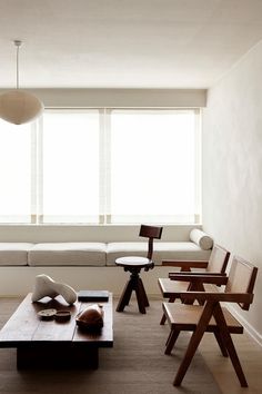 a living room filled with furniture next to a window covered in white sheets and blankets