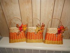 three woven baskets with fall leaves on them