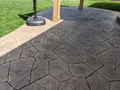 an outdoor patio with stone pavers and wooden posts