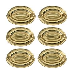 four brass plated metal knobs on a white background