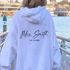 "Mrs Personalized Hoodie Wedding Gift For Bride Bride Hoodie Bridal Shower Gifts Honeymoon Sweatshirt Custom Name Custom Mrs Sweatshirt ➭ How to Order 1. Choose your hoodie size & color options. 2. Enter personalization details (last name & date). 3. Click \"Add to Cart.\" 4. Listen for a knock at your door! ➭ Care Instructions Wash your hoodie in warm water. Bleach if needed. Do not dry clean or iron directly on the design. Tumble dry on medium. ➭ Production & Shipping Processing typically take White Long Sleeve Wedding Sweater, Bride Merchandise, Bride Merch, Bride Sweats, Honeymoon Sweatshirt, Mrs Hoodie, Bridal Hoodies, Wedding Hoodie, Bride Stuff