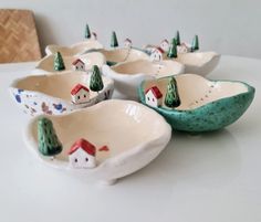 small ceramic bowls with houses and trees on them