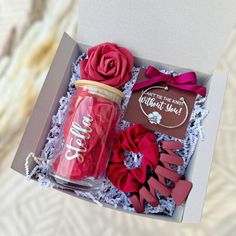 a pink box with red roses and chocolates in it is open to show the contents