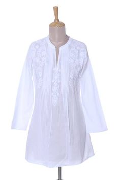 Leafy vines sway in the gentle breeze on this beautiful lightweight blouse from India. Intricate white chikankari embroidery adorns the upper areas of the blouse adding a delightfully feminine appeal to the top. Neat pintuck pleats decorate the front beneath a round neck and alongside a deep v-cut. Shalabh designs the long-sleeve white blouse with semi-sheer cotton making it a great choice to pair with a camisole. Chikankari Embroidery, White Long Sleeve Blouse, Lovely Tops, Floral White, Long Tunic, Cotton Blouse, Beautiful Blouses, V Cut, Cotton Blouses