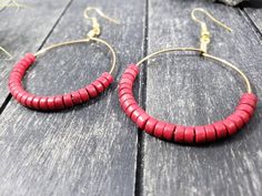 These boho beaded hoop earrings are entirely handmade! I started by wrapping gold-colored 20 gauge German wire in the shape of a circle, then added the 25 4mm x 2mm red howlite (imitation turquoise) heishi beads by hand and wrapped the wire around itself to form and secure a loop. After that, I added a gold-plated surgical steel ear wire, making these earrings safe for the most sensitive of ears. Howlite is predominantly a calming stone. It is said to calm the overactive mind and relieve stress. Adjustable Red Hoop Earrings With Dangling Beads, Handmade Red Hoop Earrings For Beach, Bohemian Red Hoop Earrings With Dangling Beads, Bohemian Red Hoop Earrings With Colorful Beads, Red Round Hoop Earrings For Festivals, Red Hoop Earrings For Festival, Red Festival Hoop Earrings, Red Hoop Earrings With Tiny Beads, Adjustable Red Bohemian Hoop Earrings