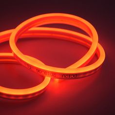 two orange glow bracelets on a dark surface