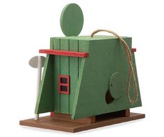 a green wooden toy house with a red door and window on the outside, attached to a rope