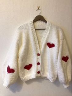 a white sweater with red hearts on it