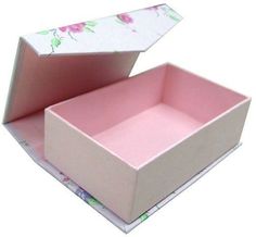 an open box with pink flowers on the lid and bottom, sitting on a white surface