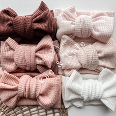 four bow ties in different colors on a wicker basket next to a white wall