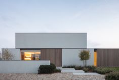 the house is made up of two large white blocks and has windows on each side