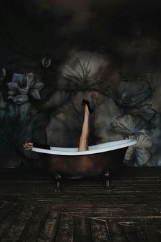 a person laying in a bathtub with their feet up