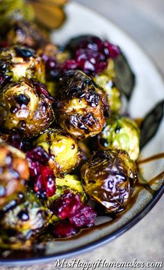 a white plate topped with brussel sprouts and cranberries