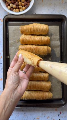 a person is holding a large piece of bread in front of some other food items